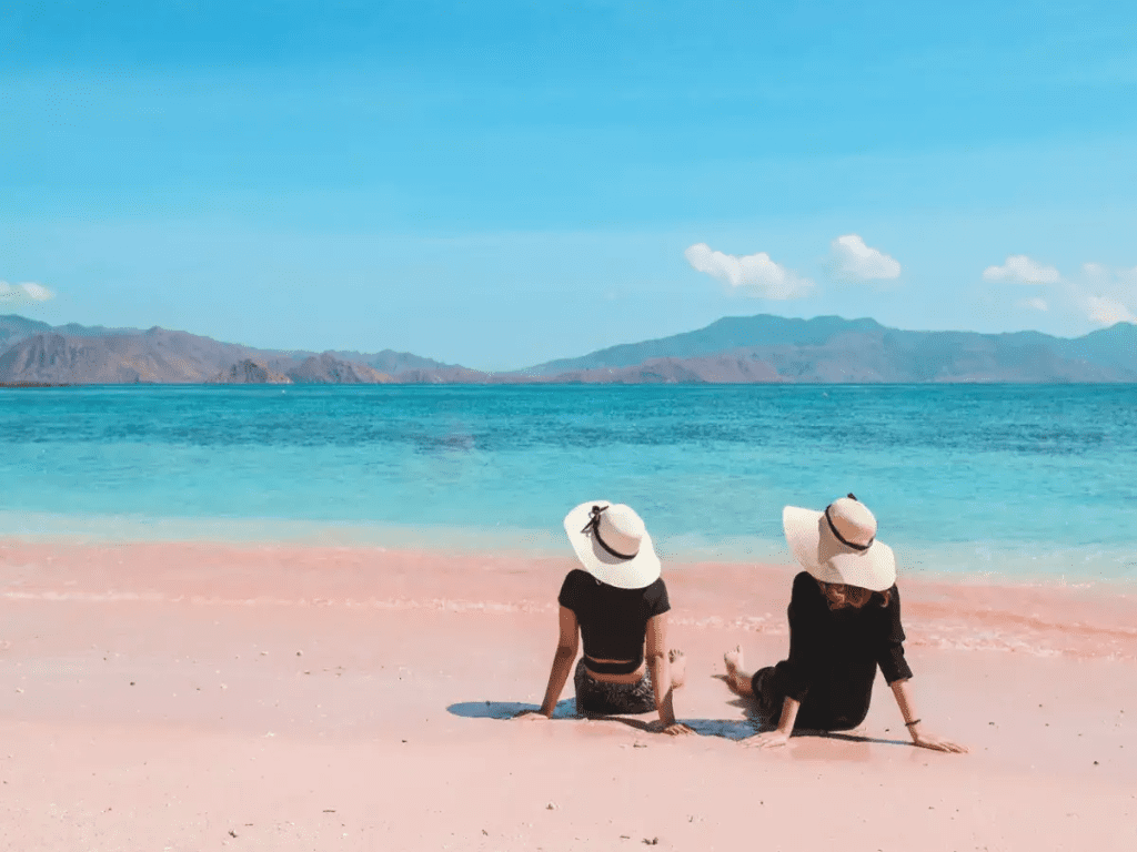 A couple sitting on pink beach Komodo