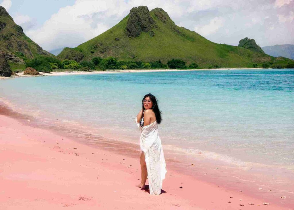 A woman standing on pink beach in Indonesia