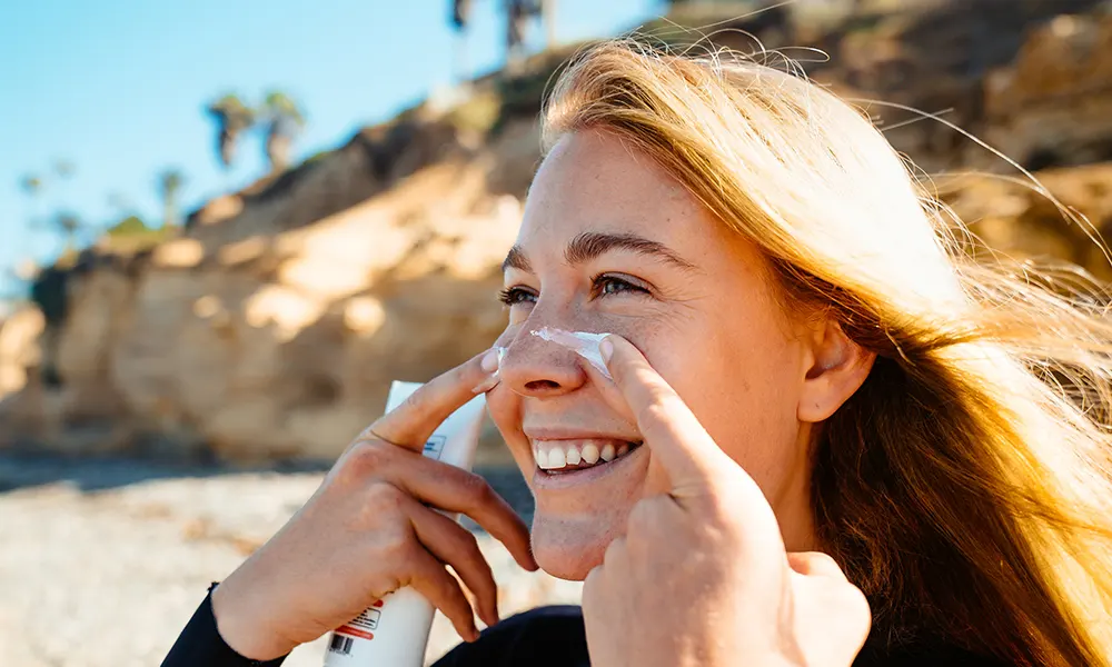 A woman applying suncreen