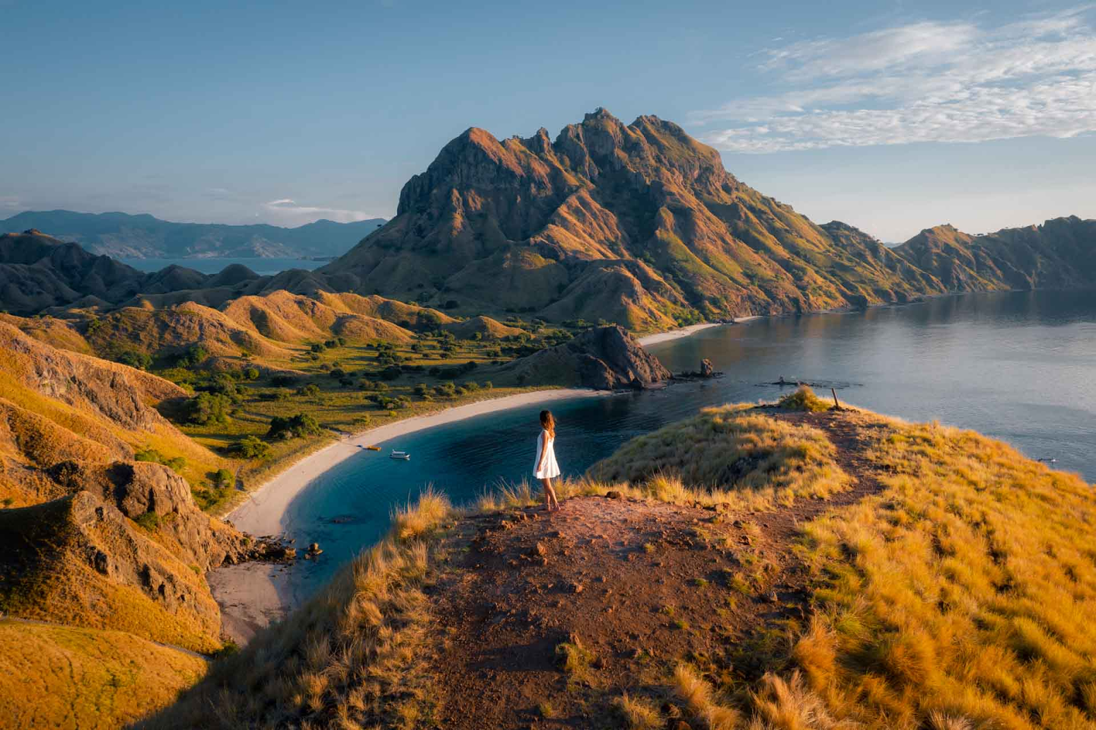 A woman standing on the viewpoint of three beaches in Padar Islands, Indonesia