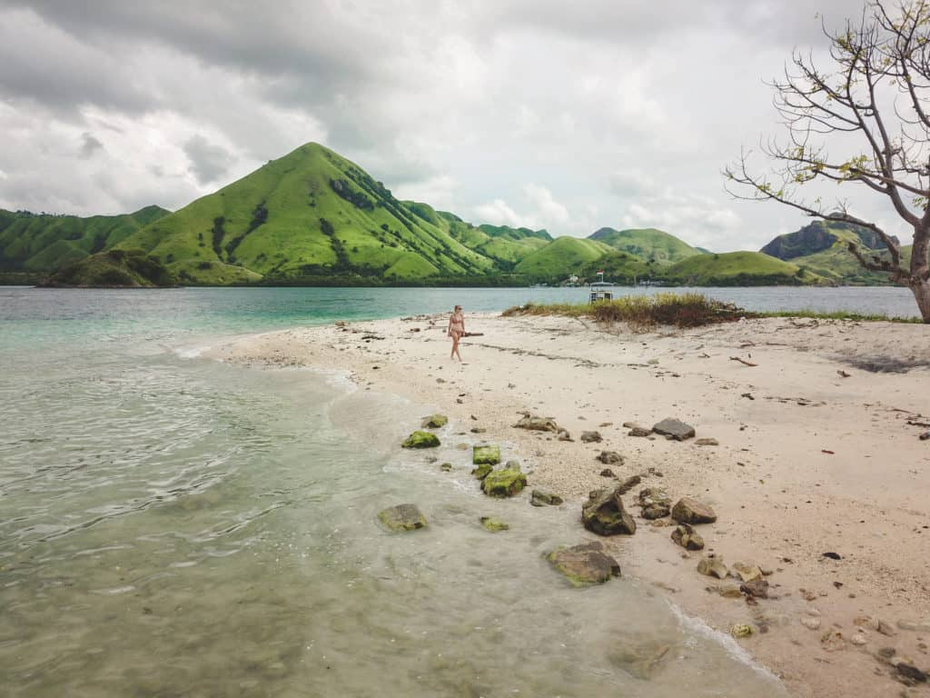 White sand and clear waters with mountain in background in Rinca, Komodo National Park