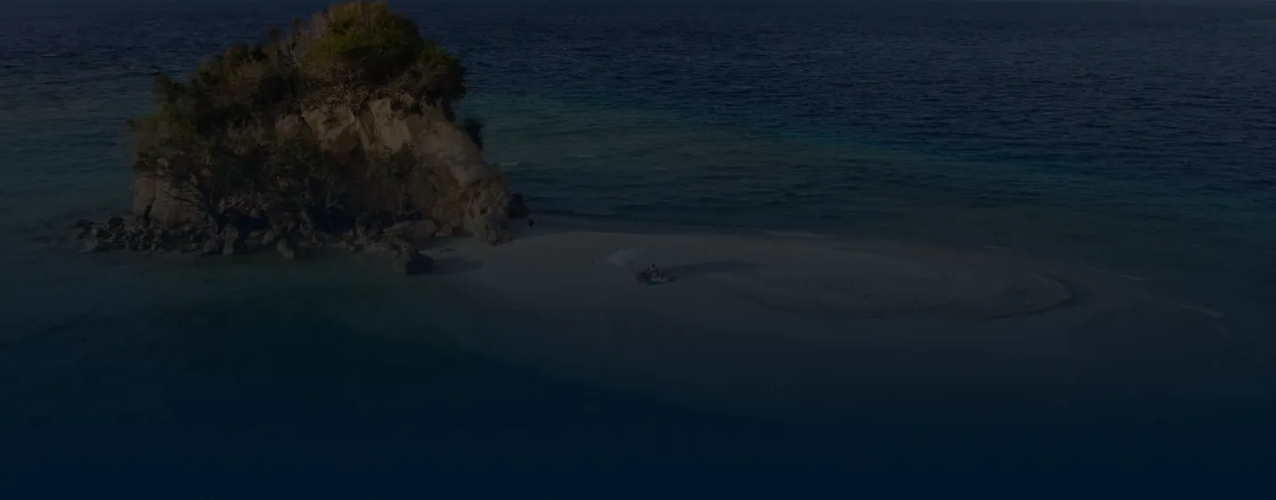 Rocky islet and sandbar in turquoise sea